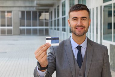 Banka kartı olan yakışıklı genç iş adamının yakın plan portresi.
