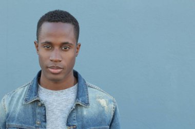 Mavi duvarın önündeki yakışıklı Afro-Amerikan 'ın yakın plan portresi.