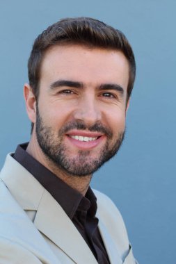 Duvarın önündeki yakışıklı sakallı adamın yakın plan portresi.