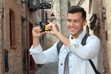 Klasik kamerayla fotoğraf çekmek için yaratıcılığını kullanan bir adam.