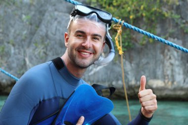 Teknede şnorkel ve maskeli yakışıklı genç adamın yakın plan portresi.