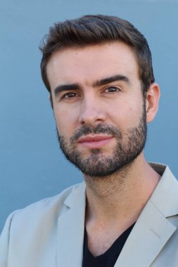 Duvarın önündeki yakışıklı sakallı adamın yakın plan portresi.