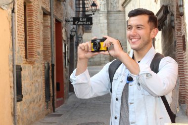 Klasik kamerayla fotoğraf çekmek için yaratıcılığını kullanan bir adam.