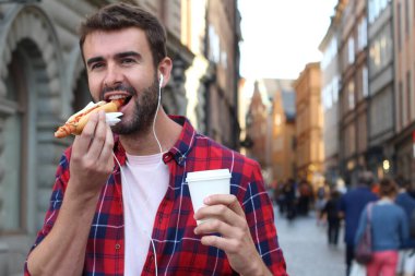 Etnik erkek dışarıda sosisli yiyor.