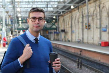 İş adamı retro tren istasyonunda yürüyor