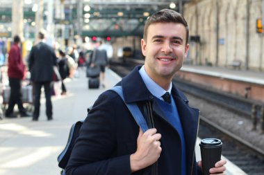 İş adamı retro tren istasyonunda yürüyor