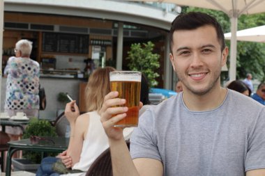 Yakışıklı erkek soğuk bir bardak birayla tezahürat yapıyor.