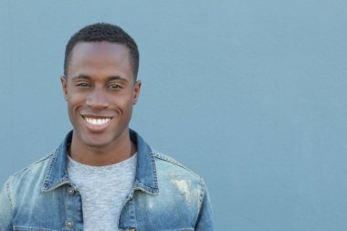 Mavi duvarın önündeki yakışıklı Afro-Amerikan 'ın yakın plan portresi.