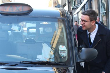 Sokakta taksiye binen yakışıklı genç adamın yakın plan portresi.