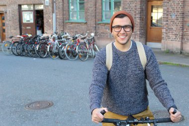 Şehirde bisiklet süren şık bir etnik adam.