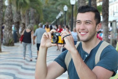 Klasik kamerayla fotoğraf çekmek için yaratıcılığını kullanan bir adam.