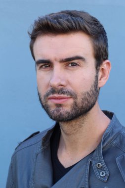 Duvarın önündeki yakışıklı sakallı adamın yakın plan portresi.