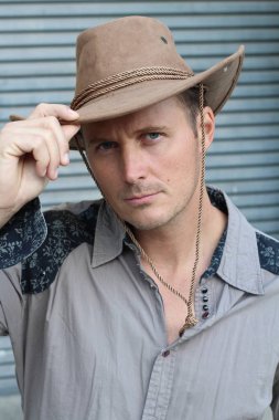 Kovboy şapkalı yakışıklı genç adamın yakın plan portresi.