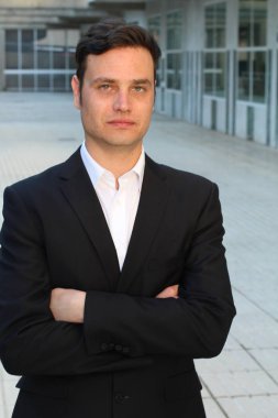 Sokakta siyah takım elbiseli yakışıklı bir adamın yakın plan portresi.