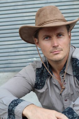 Kovboy şapkalı yakışıklı genç adamın yakın plan portresi.