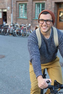 Şehirde bisiklet süren şık bir etnik adam.