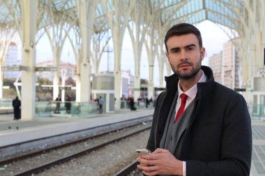 İş adamı tren istasyonundan telefonla arıyor. 