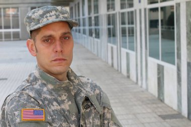 Sokaktaki üniformalı yakışıklı genç askerin yakın plan portresi.