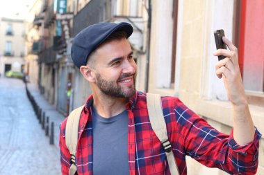 Eski şehir caddesinde sırt çantalı yakışıklı bir gencin yakın plan portresi.