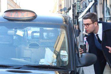 Sokakta taksiye binen yakışıklı genç adamın yakın plan portresi.