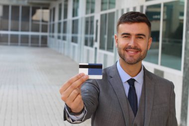 Banka kartı olan yakışıklı genç iş adamının yakın plan portresi.