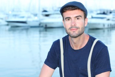 Limandaki yatların önündeki yakışıklı genç adamın yakın plan portresi.