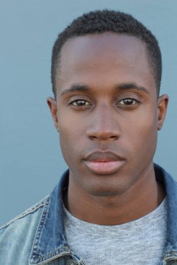 Mavi duvarın önündeki yakışıklı Afro-Amerikan 'ın yakın plan portresi.