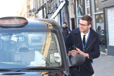 Sokakta taksiye binen yakışıklı genç adamın yakın plan portresi.