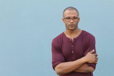 Mavi duvarın önündeki yakışıklı Afro-Amerikan 'ın yakın plan portresi.