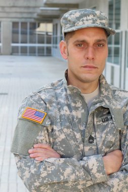 Sokaktaki üniformalı yakışıklı genç askerin yakın plan portresi.