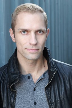 Sokakta deri ceketli, yakışıklı bir yetişkinin yakın plan fotoğrafı.