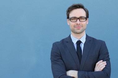 Mavi duvarın önünde genç ve yakışıklı iş adamının yakın plan çekimi.