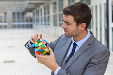 Sokakta rubik küpü tutan yakışıklı genç iş adamının yakın plan portresi.