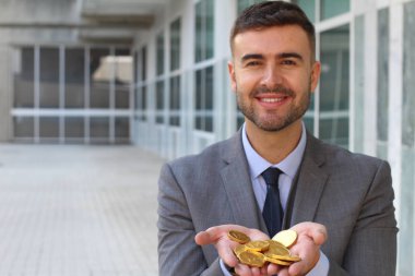 close-up portrait of handsome young businessman holding pile of golden medals on street clipart