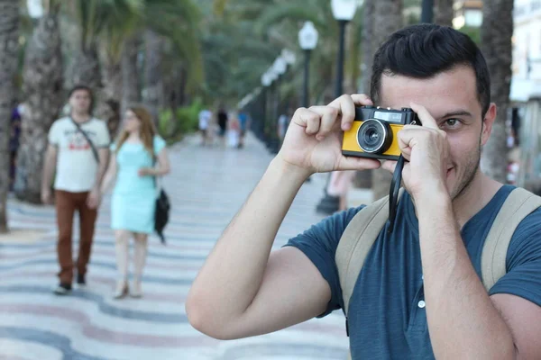 노란색 카메라가 잘생긴 관광객의 사진을 — 스톡 사진