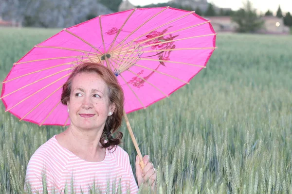 Mulher Madura Segurando Guarda Chuva Rosa Durante Dia Ensolarado — Fotografia de Stock