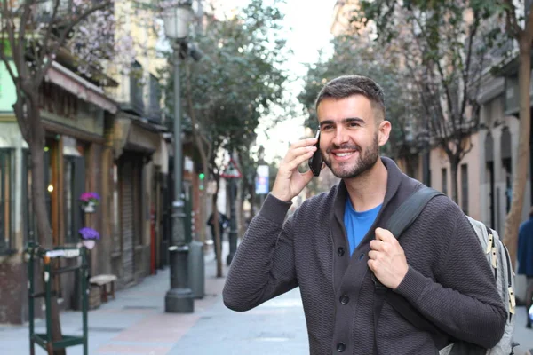 Avrupa 'nın caddesinde günlük kıyafetlerle konuşan yakışıklı genç adamın yakın plan portresi.