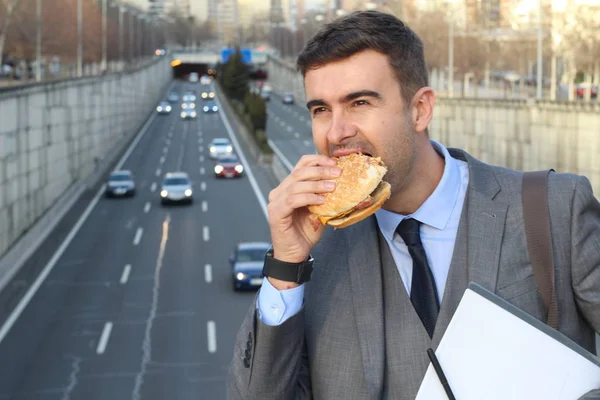 Közeli Kép Jóképű Fiatal Üzletemberről Öltönyben Hamburgert Eszik Utcán — Stock Fotó
