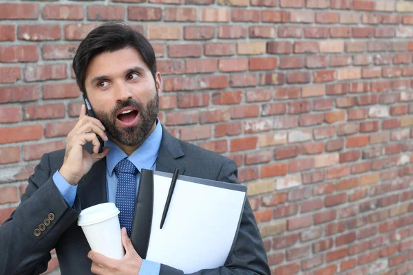 Känslomässig Man Lyssnar Telefon Med Entusiasm Tegelvägg Bakgrund — Stockfoto