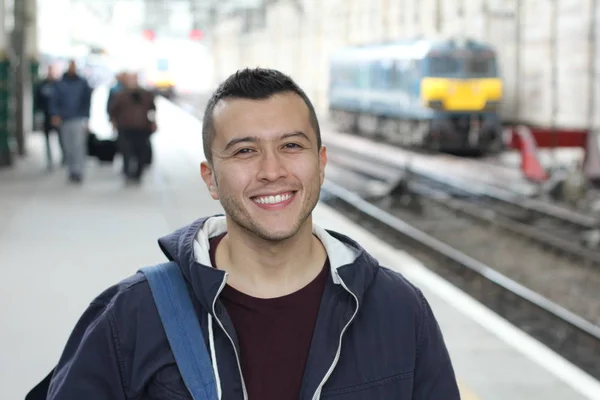 Cute ethnic young man in retro train station