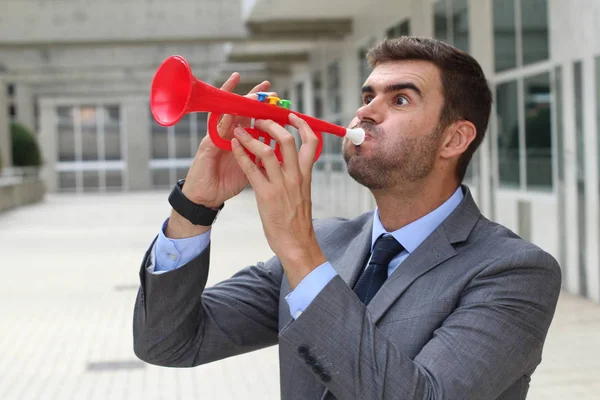 プラスチックトランペットを吹く騒々しいビジネスマン — ストック写真