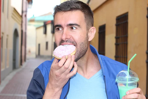 Man Eet Een Donut Drinkt Een Milkshake Buiten — Stockfoto