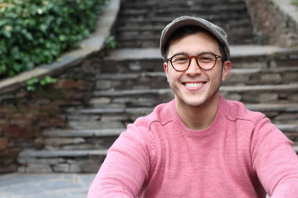 Şehir caddesinde sıradan kıyafetler giymiş yakışıklı bir gencin yakın plan portresi.