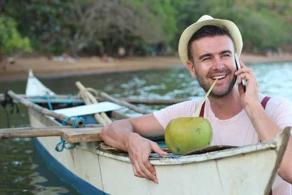新鮮なココナッツを飲みながらボートから電話でスタイリッシュな男性を呼び出します — ストック写真