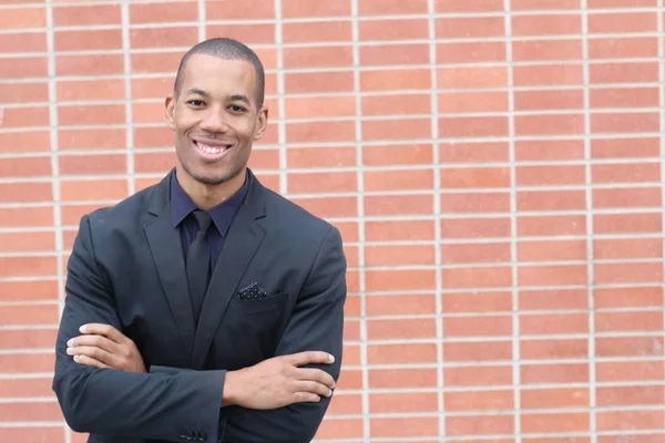 レンガの壁の前で黒いスーツを着たハンサムな若いアフリカ系アメリカ人ビジネスマンのクローズアップ肖像画 ロイヤリティフリーのストック写真