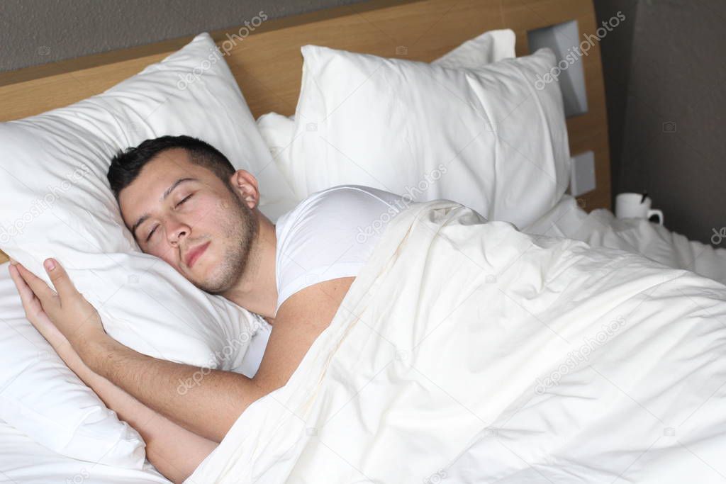 Ethnic man deeply slept in comfy bed