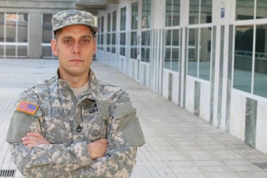 Sokaktaki üniformalı yakışıklı genç askerin yakın plan portresi.