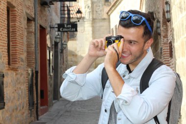 Klasik kamerayla fotoğraf çekmek için yaratıcılığını kullanan bir adam.