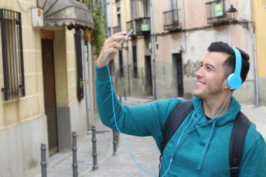 Genç etnik adam dışarıda teknoloji kullanıyor.