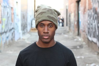 Siyah tişörtlü ve şapkalı yakışıklı Afro-Amerikan adamın yakın plan portresi.